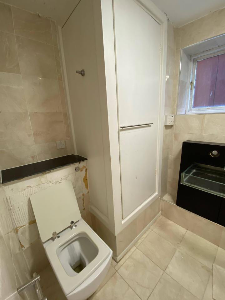 Bathroom under renovation with toilet and cabinet.
