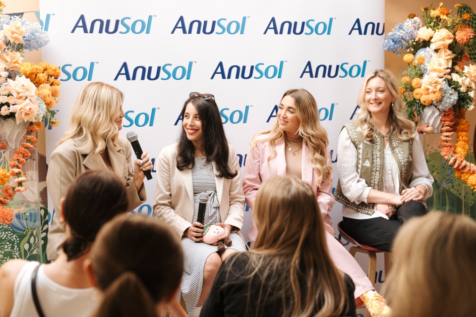 Four women sitting on stage speaking to an audience with the Anusol logo behind them.