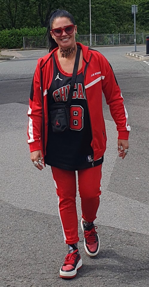 Woman in red tracksuit and Chicago Bulls jersey with “Pink Army” written on her neck.