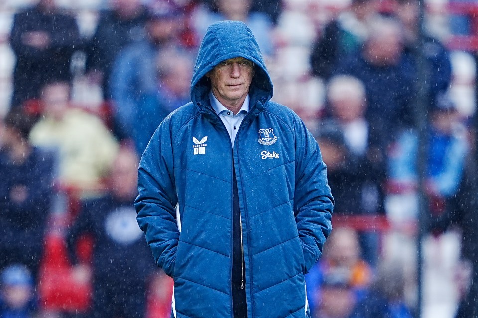 Everton manager David Moyes in a hooded jacket on a rainy day.