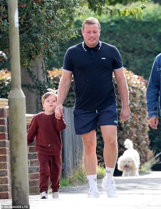 Thomas cut a casual figure in a navy Hugo Boss polo shirt and shorts as he strolled along the street holding five-year-old Henry's hand