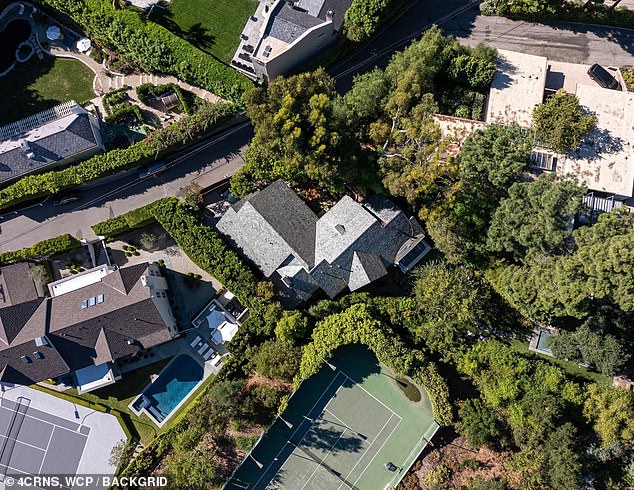 Downstairs is a huge white kitchen with stainless steel appliances while outside is a pool with privacy thanks to huge trees and bamboo shoots