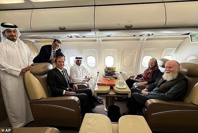 Qatari and British diplomats, left, pose with the released British couple, Barbie and Peter Reynolds, aboard a plane before departing to Qatar from Kabul, Afghanistan