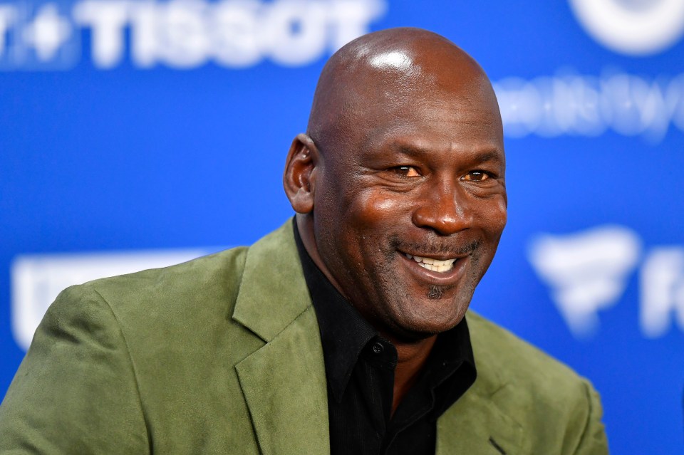 Michael Jordan smiling at a press conference.