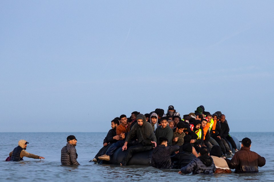 Migrants attempting to board a smuggler's boat to cross the English Channel.