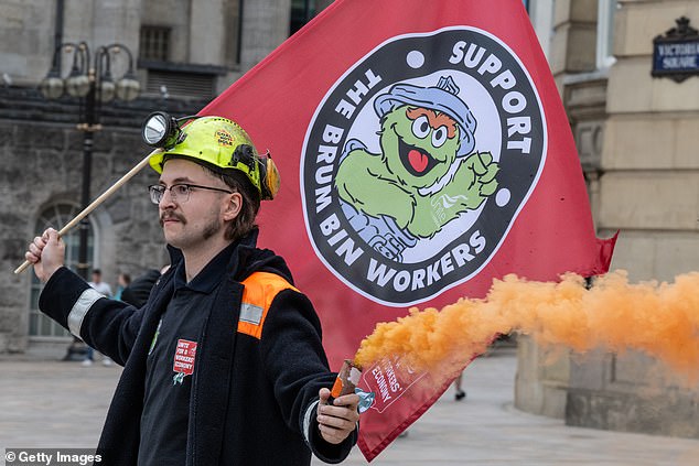 One worker was seen holding an orange smoke bomb as he held a 'Support the Brum Bin Workers' flag