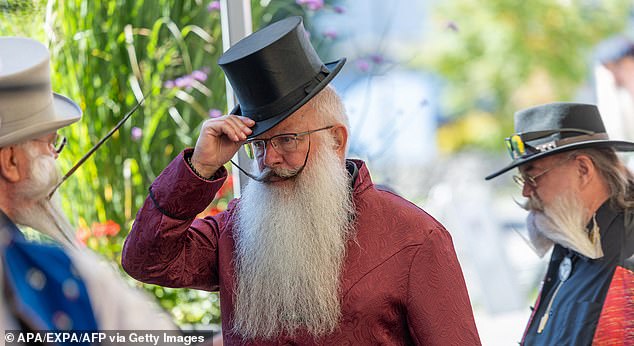 A man tips his top hat to another competitor as they arrive at the competition earlier today
