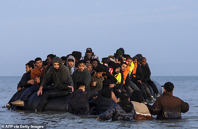 Migrants try to board a smuggler's boat in an attempt to cross the English Channel on Friday
