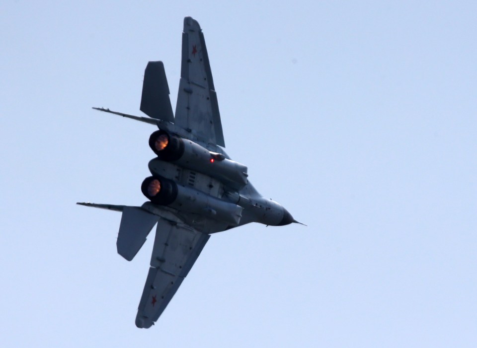 A Mikoyan MiG-31 jet fighter aircraft with two visible jet engines with glowing exhaust.