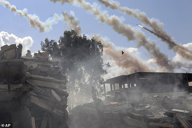 Peacebuilding is a dirty endeavour that requires making queasy moral choices, stomaching compromises and looking beyond each other's crimes. Pictured: Rockets fly over destroyed buildings after Israeli air strikes on Gaza City on October 19, 2023