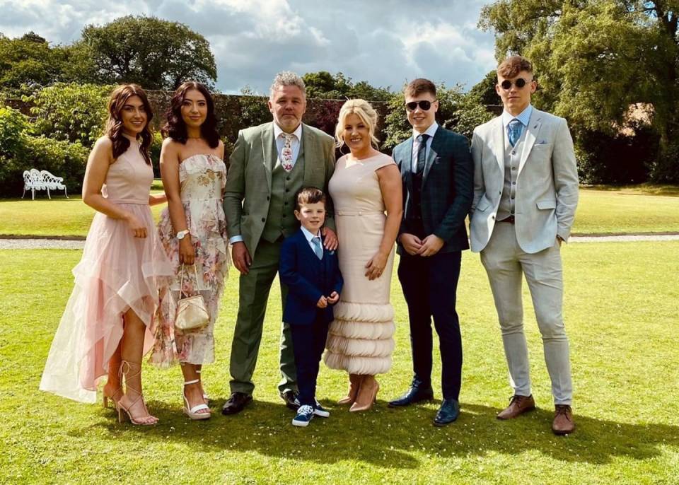 Family portrait of seven people on a lawn.