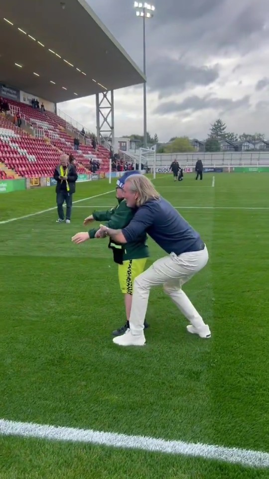 Paul Gascoigne with a boy on a football pitch.