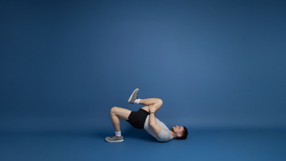 A man doing a single-leg bridge exercise.