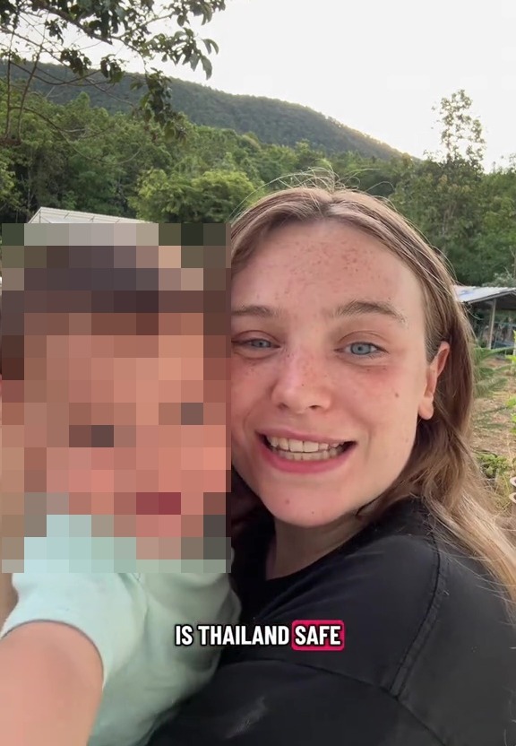 A smiling woman holding a child with a pixelated face, with the text "IS THAILAND SAFE" overlaid.