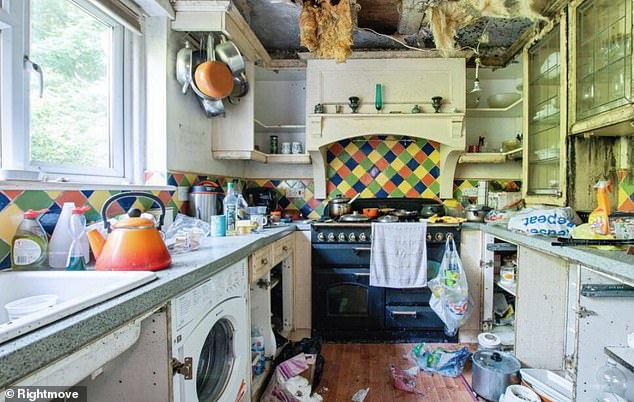 In the kitchen, insulation hangs from the ceiling. A Tesco bag full of rubbish dangles from one of the cooker's knobs with crockery piled haphazardly on the draining board