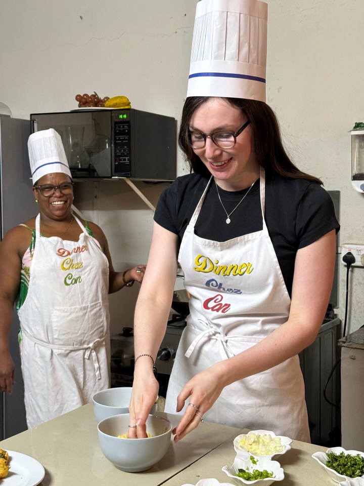 Alice Fuller wearing a chef's hat and apron while preparing food in Mauritius.