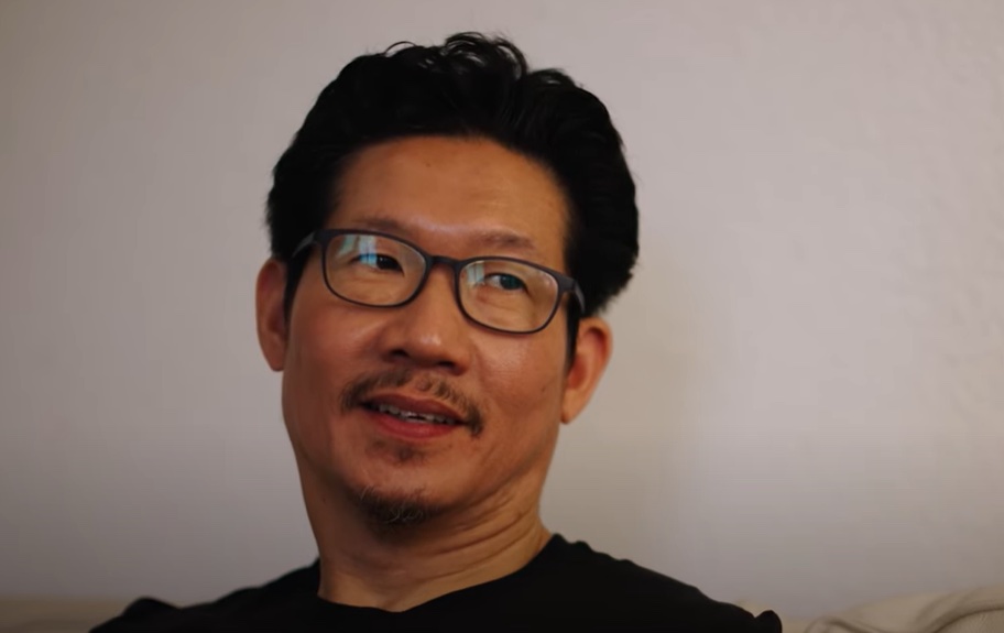 Tyrone looking directly at the camera, smiling slightly.