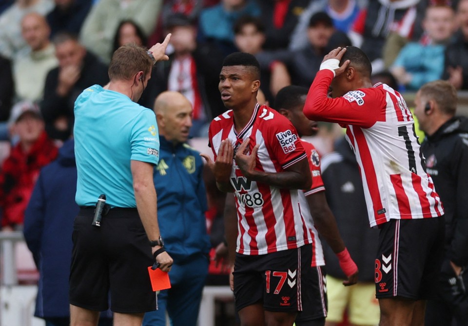 Referee Samuel Barrott shows a red card to Sunderland's Reinildo Mandava.