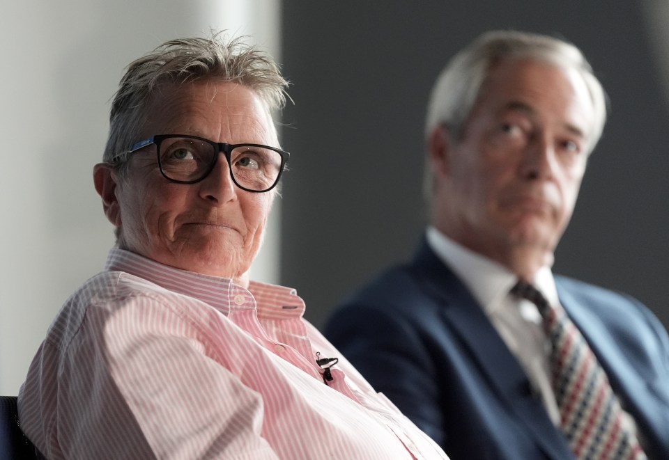Vanessa Frake, Reform UK's new justice adviser, in a pink striped shirt, sits next to Nigel Farage, Reform party leader, in a suit and tie, both looking forward.