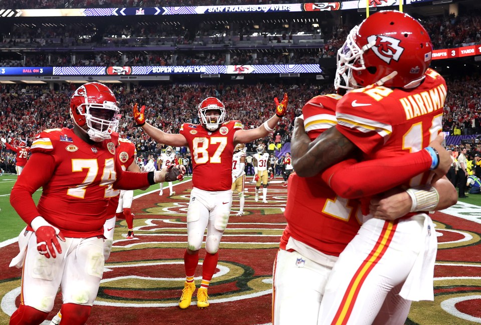 Kansas City Chiefs players Mecole Hardman Jr., Patrick Mahomes, and Travis Kelce celebrating after the game-winning touchdown pass in Super Bowl LVIII.