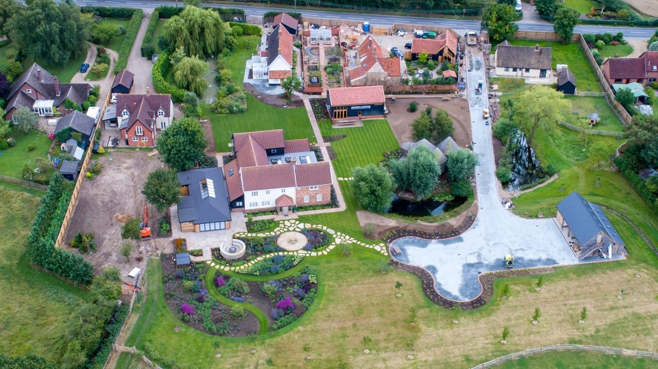 Aerial view of Ed Sheeran's home in Suffolk, showing a large estate with multiple houses, gardens, and ongoing construction.