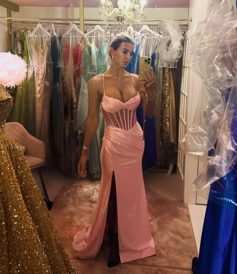 Christine McGuinness posing in a long pink dress with a thigh-high slit and a sparkling bodice.