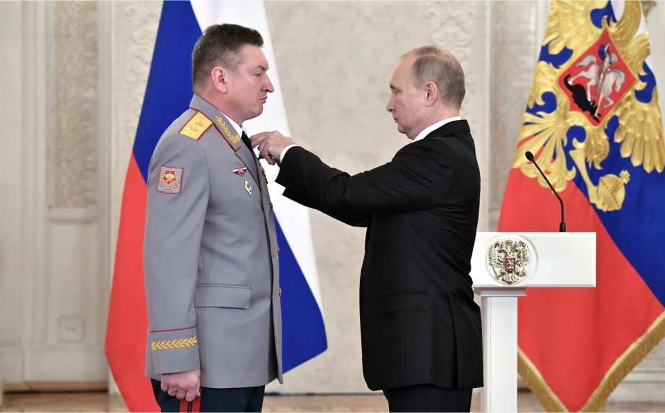 Vladimir Putin pinning a medal on Colonel General Alexander Lapin.