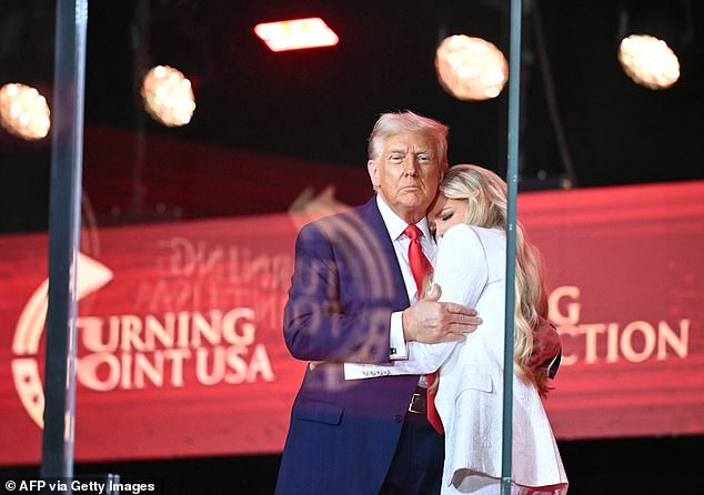 President Donald Trump hugs an emotional Erika Kirk after inviting her on stage at the end of his speech. He said of Kirk's of assassination: 'The gun was pointed at him, but the bullet was aimed at every one of us'