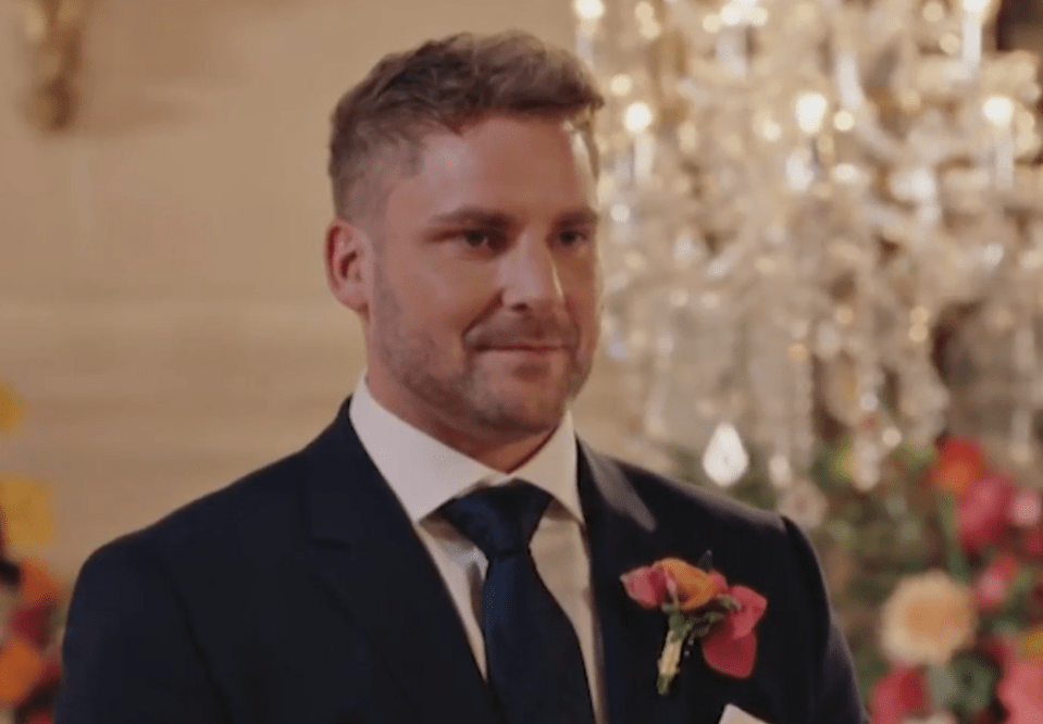 A man in a suit with a floral boutonnière.