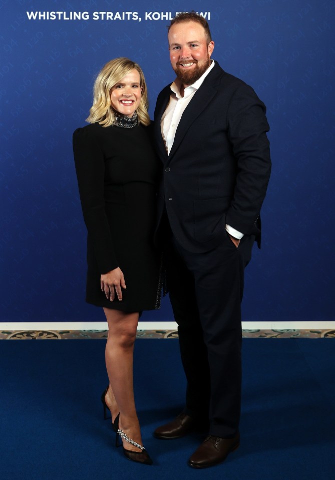 Shane Lowry and his wife Wendy Honner posing at the Team Europe Gala Dinner with the Ryder Cup Europe 2020 logo in the background.