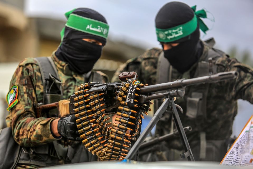 Hamas fighters securing an area before handing over Israeli hostages in Deir el-Balah, central Gaza.