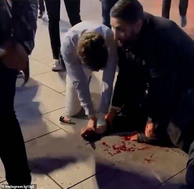 Blood can be seen covering the alleged attackers hands before another security guard appeared to find the knife discarded on the ground