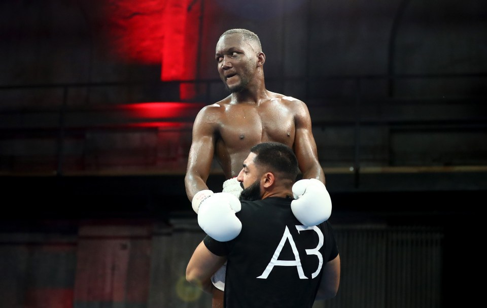Boxer Abass Baraou of Germany celebrates, carried on another person's shoulders.