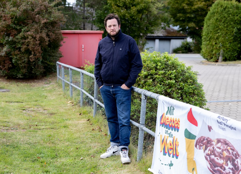 Sun reporter Rob Pattinson stands where Brückner was photographed in front of a red building and a banner for McDonald's McFlurry.
