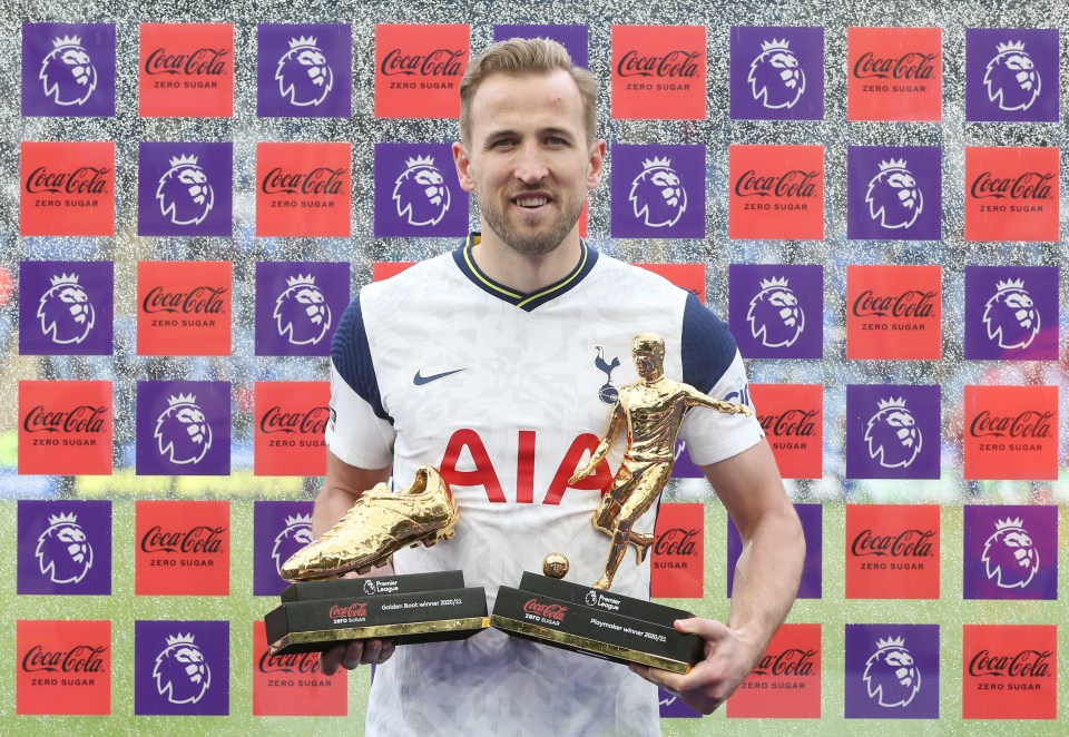 Harry Kane holding the Golden Boot and Playmaker trophies.