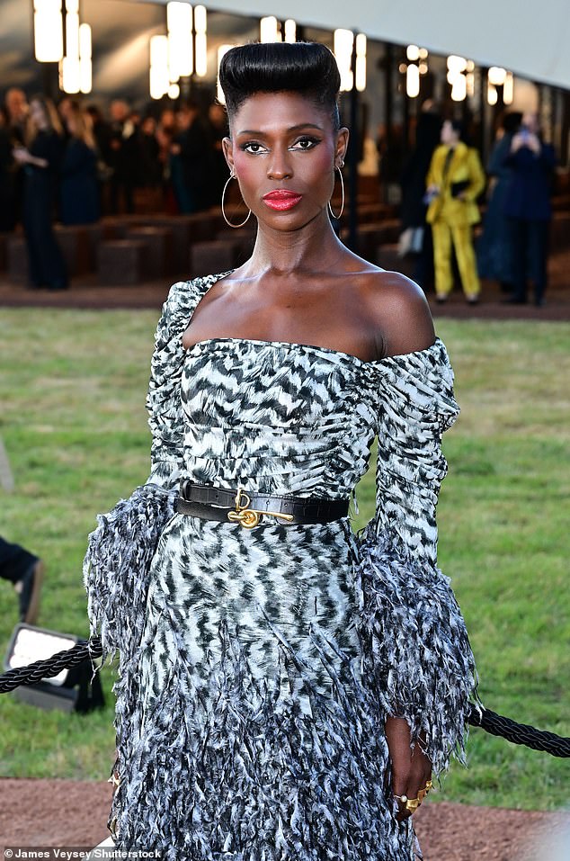 She styled it with two black belts to accentuate her tiny waist and large hoop earrings, while sporting a classic victory rolls hairstyle and bold graphic eyeliner