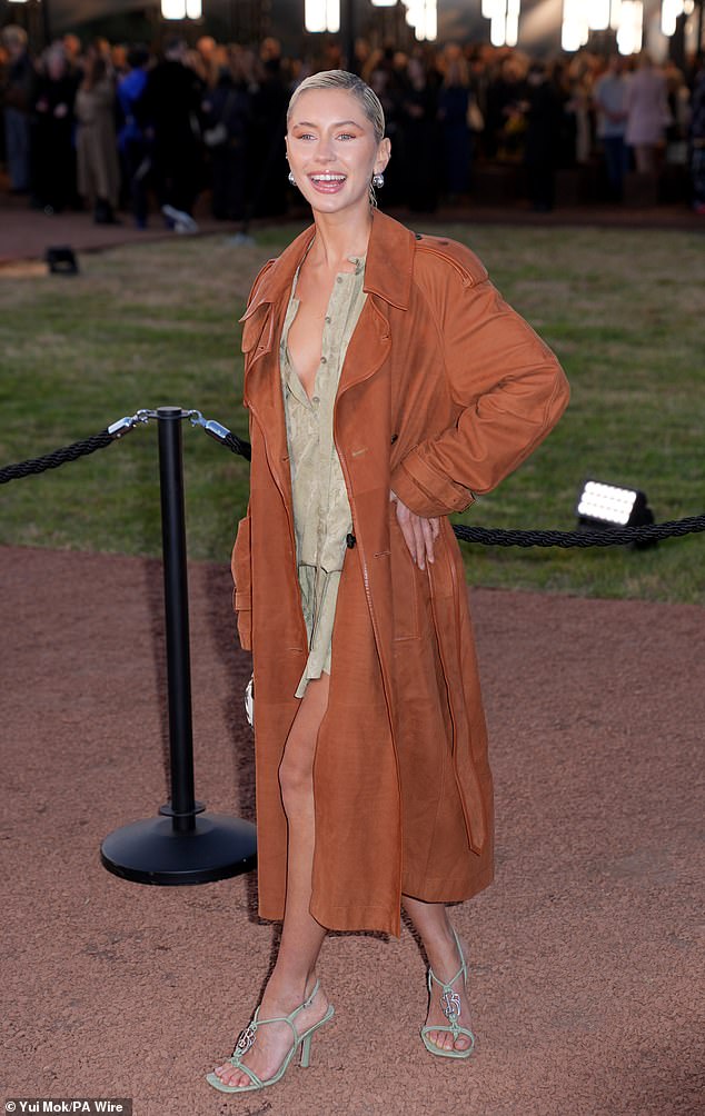 The model daughter of Jude Law and Sadie Frost layered a trendy tan trenchcoat over the top, elevating the look with strappy green heels and statement silver earrings