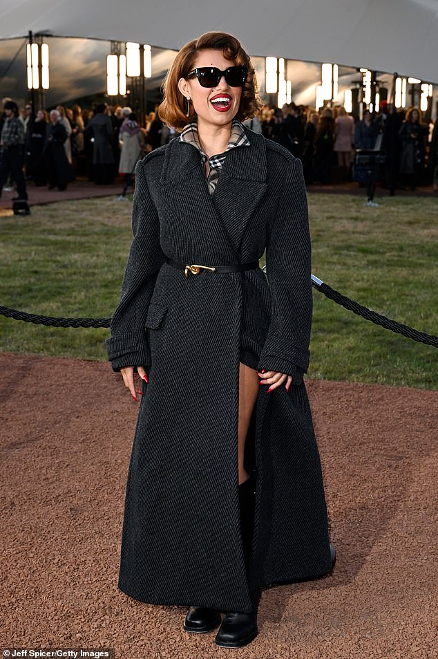 RAYE was the picture of elegance in a charcoal grey tailored coat belted at the waist to highlight her incredible figure