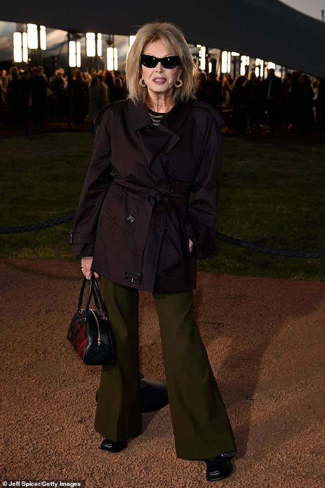 Joanna, 79, put on an age-defying display in a dark purple jacket and flared khaki trousers, with futuristic black shades
