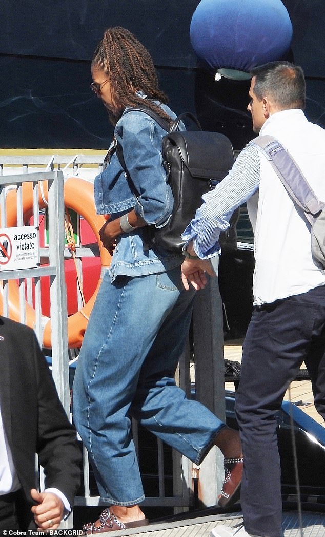 She wears baggy jeans, a matching denim button-down top and some brown Birkenstocks
