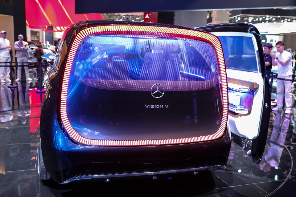 Rear view of a Mercedes-Benz Vision V concept vehicle with illuminated taillights.