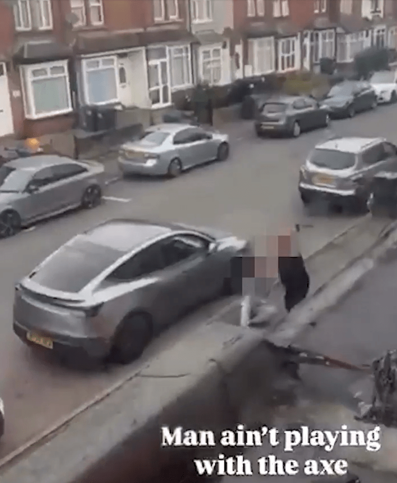 A blurred figure in a street holding an axe near a parked car.
