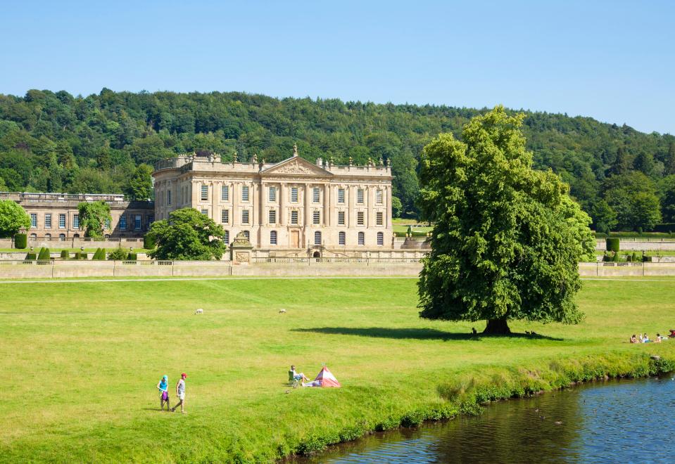Chatsworth House with parkland, the River Derwent, and woods.
