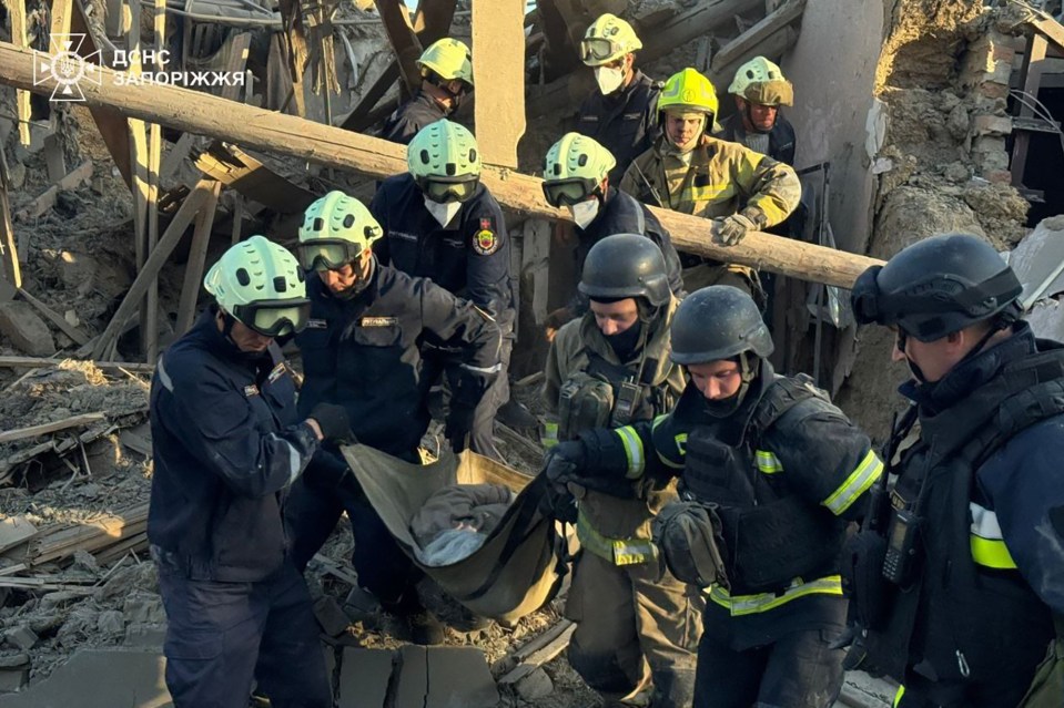 Ukrainian rescuers carry the body of a person killed in an air attack in Zaporizhzhia.