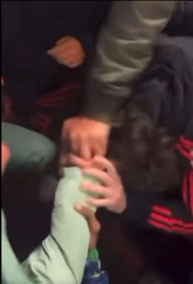 Hands holding a person's ankle as if providing medical assistance.