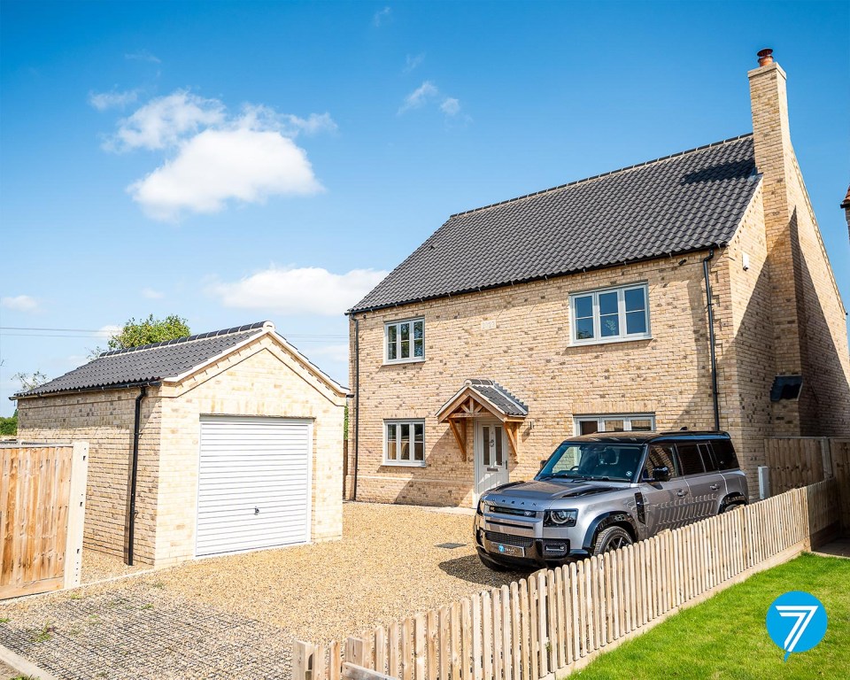 Two-story house with attached garage and Land Rover parked in driveway.