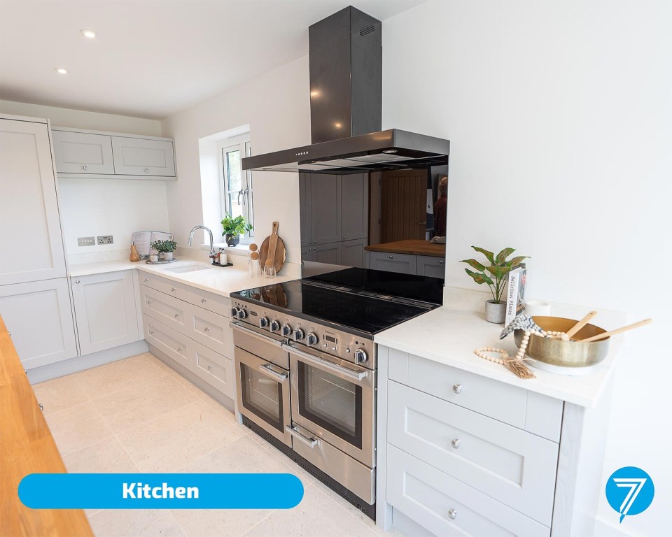 Modern kitchen with gray cabinets and stainless steel appliances.