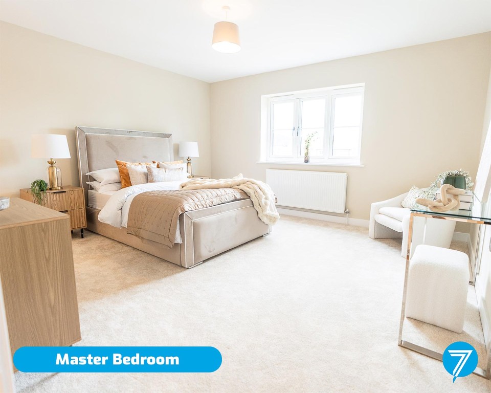 Master bedroom with large bed, side tables, and seating area.