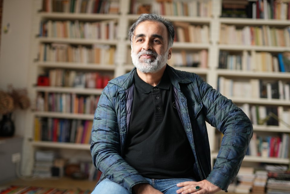 Abderrahmane Ouatiki sitting in a chair in front of bookshelves.