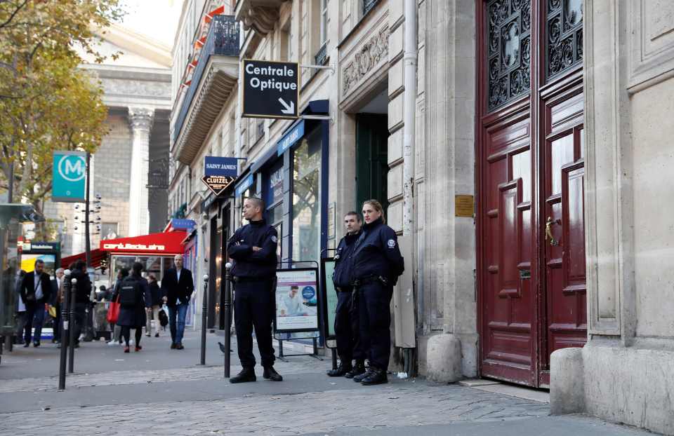 Police officers standing guard outside a hotel residence in central Paris.